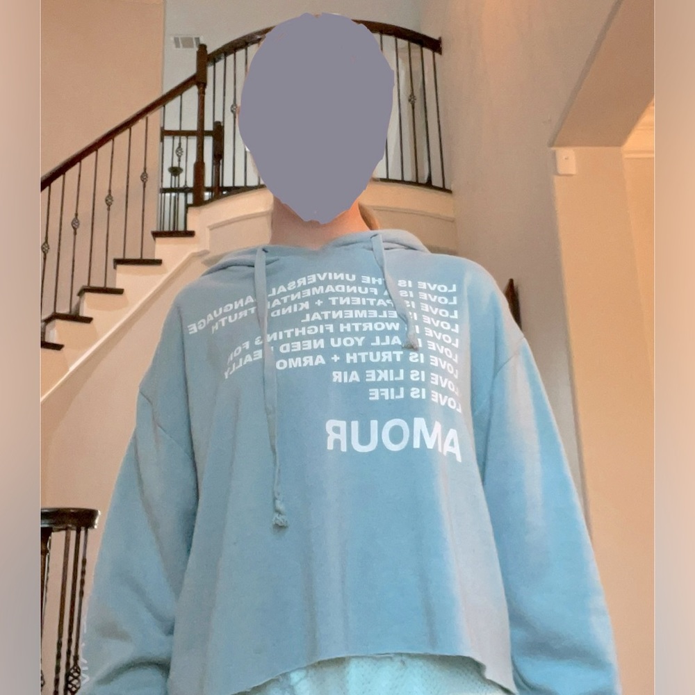 It’s a dusty blue sweatshirt/crop top that’s talking about love on the front
